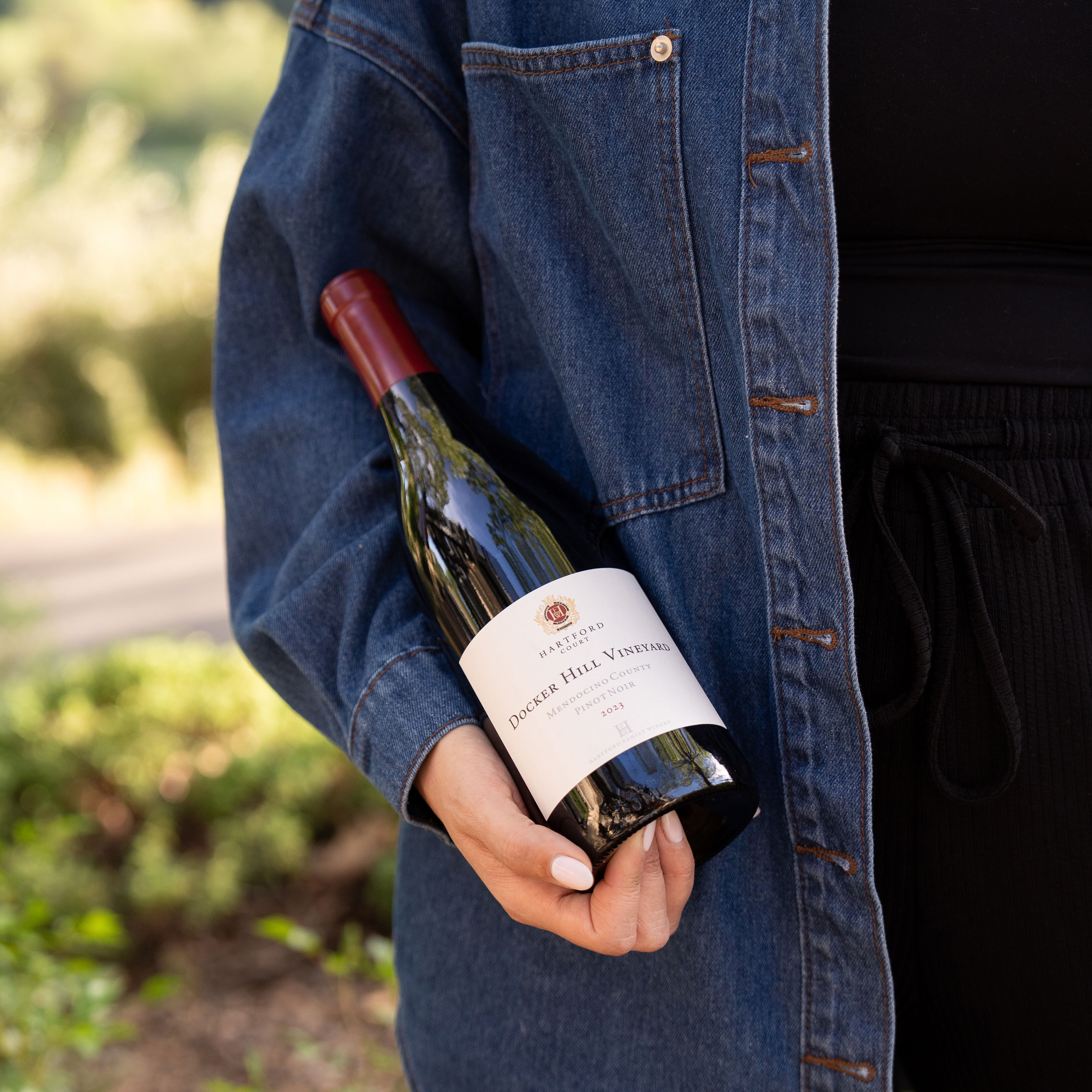 A person holding a bottle of Hartford Pinot Noir