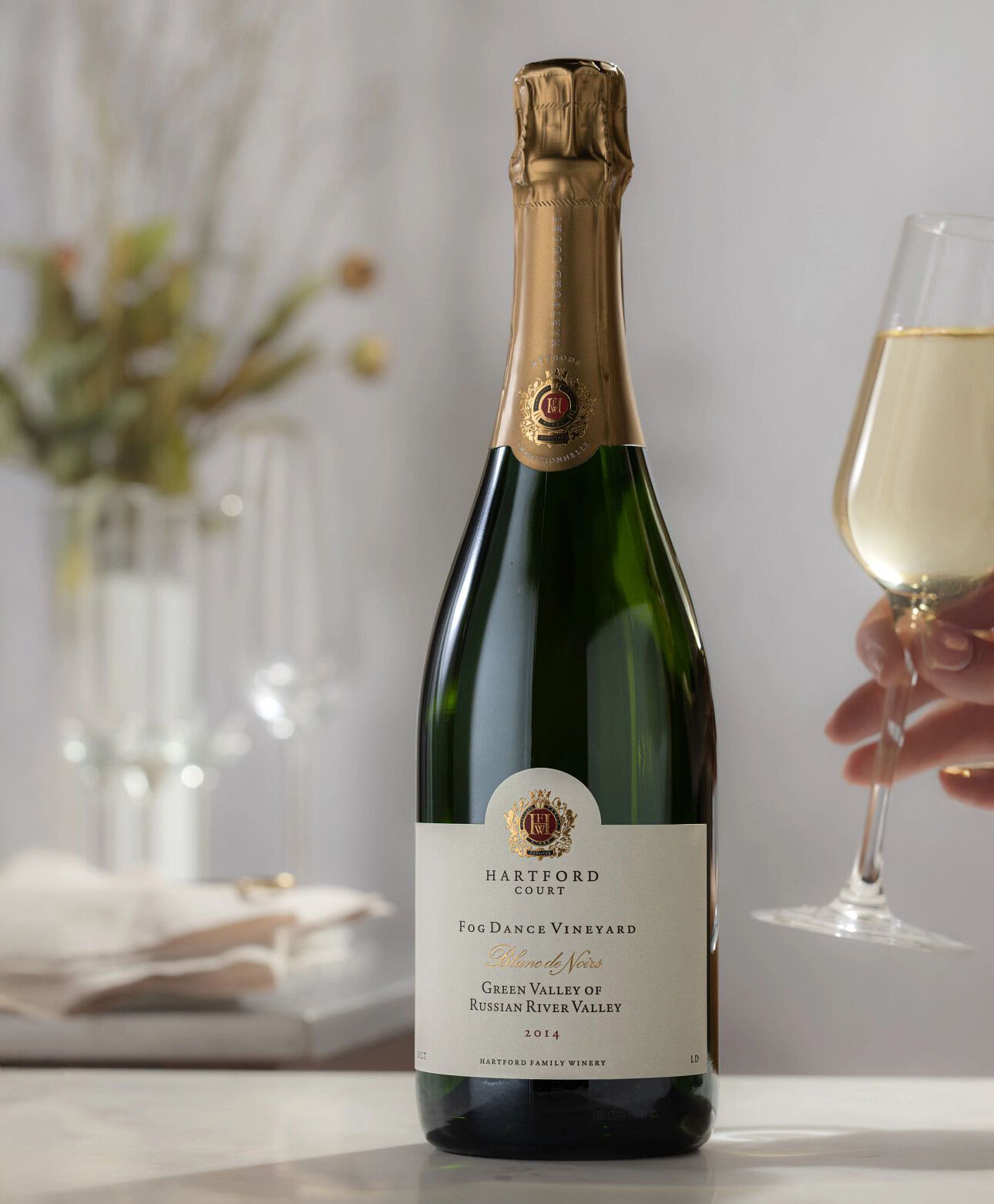 A bottle of Hartford sparkling wine with a person holding a glass