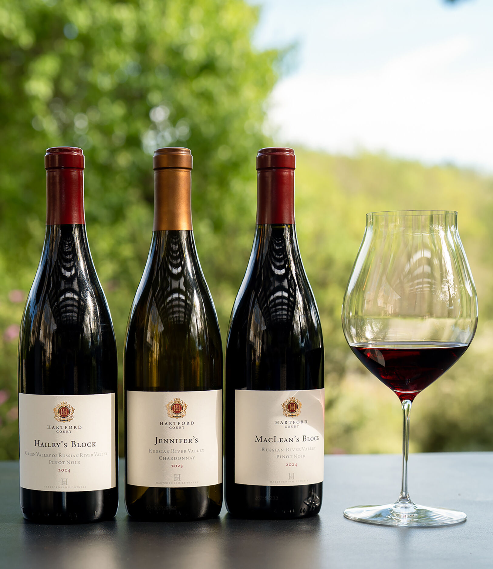 A lineup of Hartford wine bottles with a glass of red wine